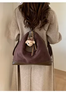 Deep brown suede tote bag featuring a cute plush dog charm and gold ring detail