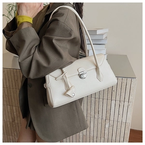 Detail of a creamy white Boston bag featuring a silver metal buckle and premium leather texture