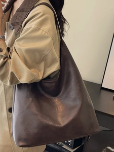 Vintage dark brown PU leather tote bag shown with a khaki trench coat for autumn style