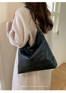 Detail der schwarzen Hobo-Tasche mit geometrischen Nähten und goldenem Kettenriemen