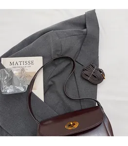 Détail du sac bandoulière en cuir marron foncé avec fermoir rotatif en or vintage