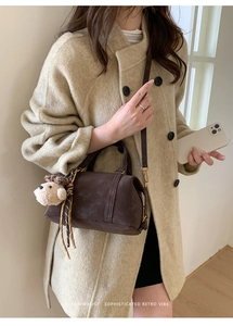 Retro dark brown cylinder handbag styled with beige wool coat and cute puppy pendant