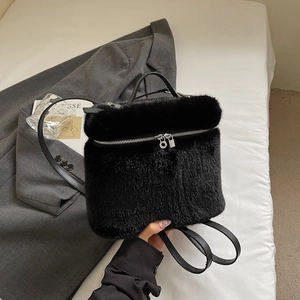 Detail eines schwarzen Plüschrucksacks mit silbernem Reißverschluss auf dem Sakko