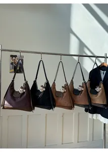 Suede tote bags in five earthy tones hanging on a rack with cute bear charms