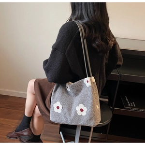 Détail du sac cabas en feutre gris avec motifs floraux blancs et fines anses noires
