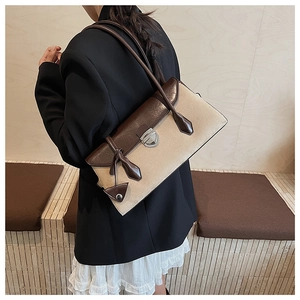 Detailed view of vintage canvas and brown leather patchwork shoulder bag with tassels