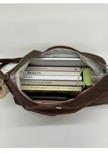 Spacious interior of dark brown tote bag showing capacity for tablet, books, and umbrella
