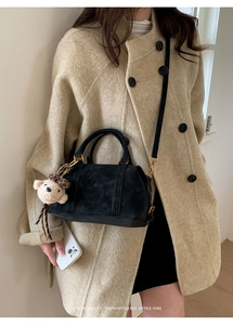 Detail of black crossbody bag with Skert Air Paris logo and khaki plush bear charm
