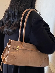 Brown vintage large baguette bag in suede with double straps worn by a model in a blazer