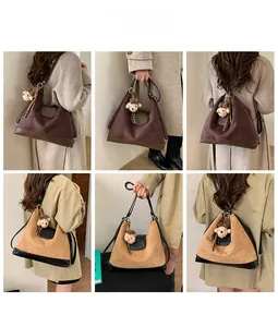 Detail view of large matte leather tote bag with bear pendant in various carrying styles
