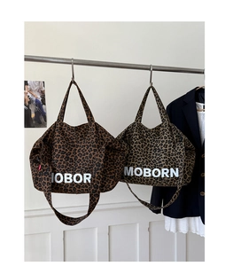 Detail of leopard print tote bags in light and dark patterns with white MOBORN lettering
