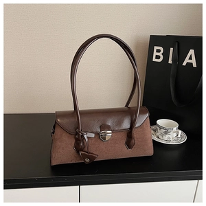 Detailed close-up of vintage brown shoulder bag showing suede and smooth leather texture
