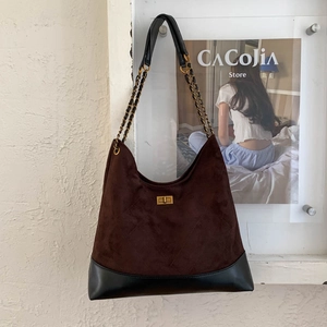 Detail der hobo-tasche aus dunkelbraunem veloursleder mit goldverschluss und kettengurt