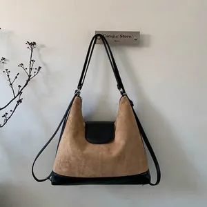 Detail of vintage brown suede tote bag with black leather base and dual straps