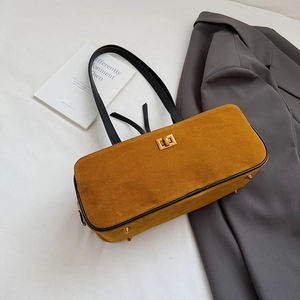 Detail of yellow suede bag with gold twist lock and protective metal feet on bottom