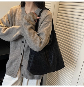 Detailed close-up of dark leopard print hobo tote bag on model for casual daily use