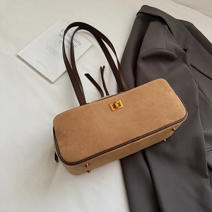 Macro shot of khaki suede baguette bag featuring golden metal clasp and brown straps