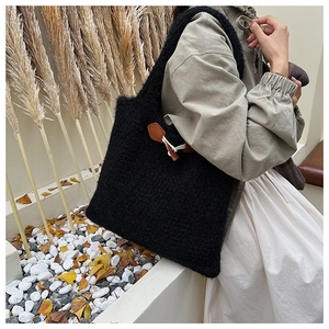 Detail of black fuzzy crochet tote bag featuring vintage leather horn buckle accent