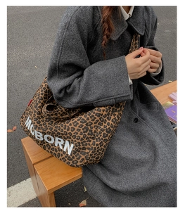 Close-up of leopard print canvas tote bag with MOBORN logo in a street style setting