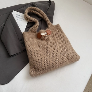 Detail of mocha hollow knit tote bag featuring a vintage horn buckle and textured weave