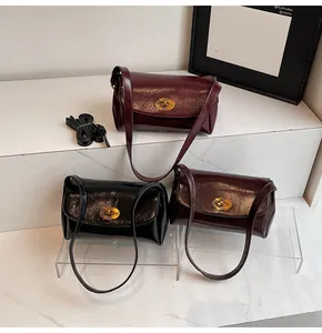 Détails de sacs à main rétro brillants en bordeaux, noir et marron avec boucles dorées