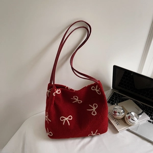 Détail du sac cabas en laine rouge avec broderie nœud beige et fine bandoulière en cuir