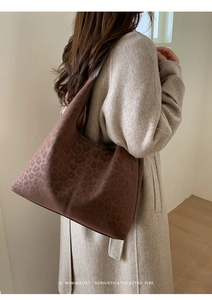 Détail d'un grand sac cabas avec imprimé léopard en daim mat porté sur l'épaule pour femme