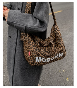 Close-up of leopard print tote bag with white MOBORN lettering and wide shoulder strap