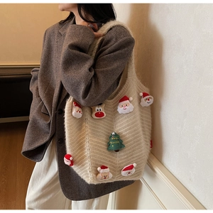 Detailed knit texture of festive cream shoulder bag with Santa and reindeer 3D patches
