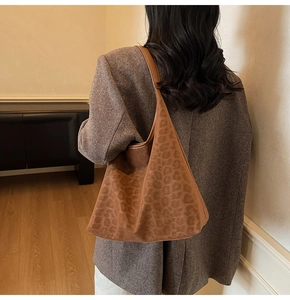 Close-up of leopard print tote bag with soft suede texture on a model's shoulder