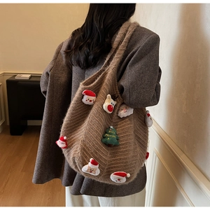 Detail of a brown woven tote bag featuring festive Christmas plush patches and holiday motifs