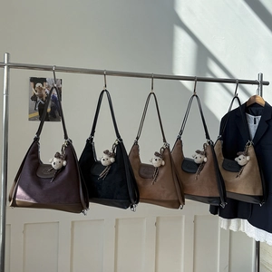 Detail of five vintage suede tote bags in various earth tones with cute bear charms