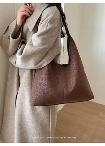 Gros plan d'un sac cabas léopard rétro avec bandoulière en cuir marron sur l'épaule
