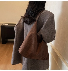 Detail view of large leopard print hobo shoulder bag with smooth brown leather strap