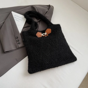 Detail of black faux fur tote bag featuring a leather toggle closure and rope accents
