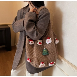 Detail of warm brown knit tote bag with Santa Claus and festive 3D plush decorations