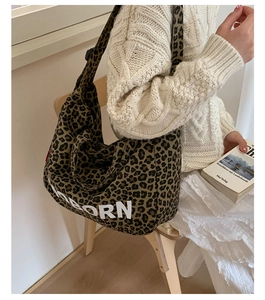 Detail of leopard print tote bag featuring white BORN lettering and canvas texture
