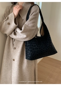 Détail du sac hobo léopard vintage avec bandoulière en cuir sur mannequin en manteau