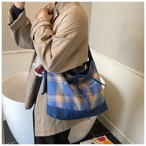 Detail of blue and beige checkered canvas tote bag with drawstring and printed text