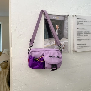 Detailansicht der lila Nylon-Umhängetasche mit Kordelzug-Netztasche und gelber Kordel