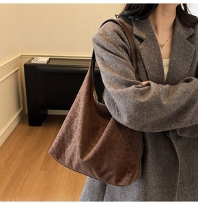 Macro side view of a large leopard print tote bag worn on shoulder by a model