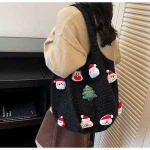 Detail of black knit tote bag featuring cute Christmas 3D plush charms and holiday embroidery