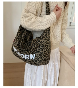 Detail of leopard print tote bag with UNBORN text and wide shoulder strap