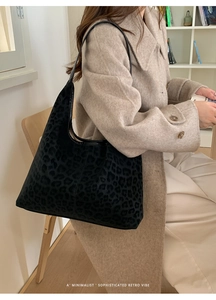 Détail du sac hobo à imprimé léopard en suédine avec bandoulière en cuir noir