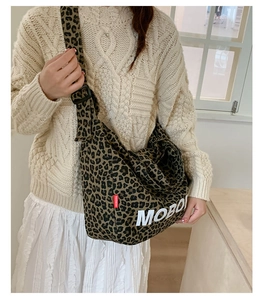 Detail of leopard print tote bag with white letter print and wide crossbody strap