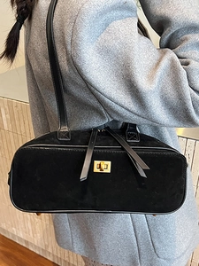 Minimalist black suede baguette bag with gold twist lock and slim leather straps for women