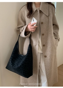 Sac fourre-tout chic à imprimé léopard porté avec un manteau en laine pour un look rétro