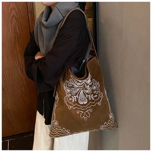 Detailed close-up of bohemian floral embroidery on brown faux suede large tote bag