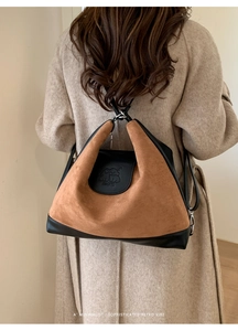 Close-up of a large vintage tote bag with elephant embossing on soft brown suede