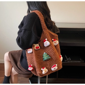 Detail view of woven brown tote bag with 3D plush Christmas Santa and reindeer patches